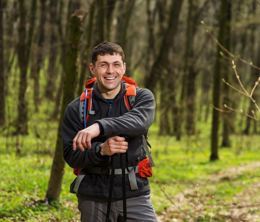 Westside Behavioral Care Kaiser Prescribers Westside Behavioral Care Meet our Kaiser Prescribers Section - Happy man in hiking gear with a red backpack and trekking poles standing on a trail in a forest with fresh green foliage.